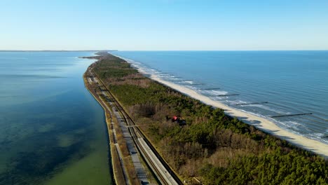 Cars-Driving-Through-Narrow-Road-In-Kuznica-Poland---aerial-shot