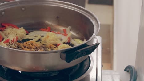 salpicando y sazonando sal sobre brotes de bambú salteados para hacer ginisang labong, un auténtico plato tradicional local filipino