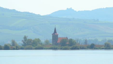 zoom out move view of a church lying in the middle of a lake