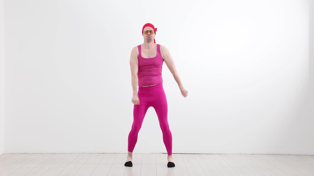 Uomo in tenuta rosa e bandana che balla in modo divertente