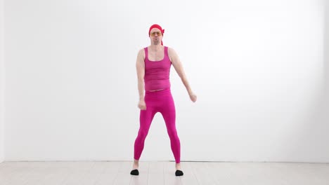 man in pink outfit and bandana dancing humorously