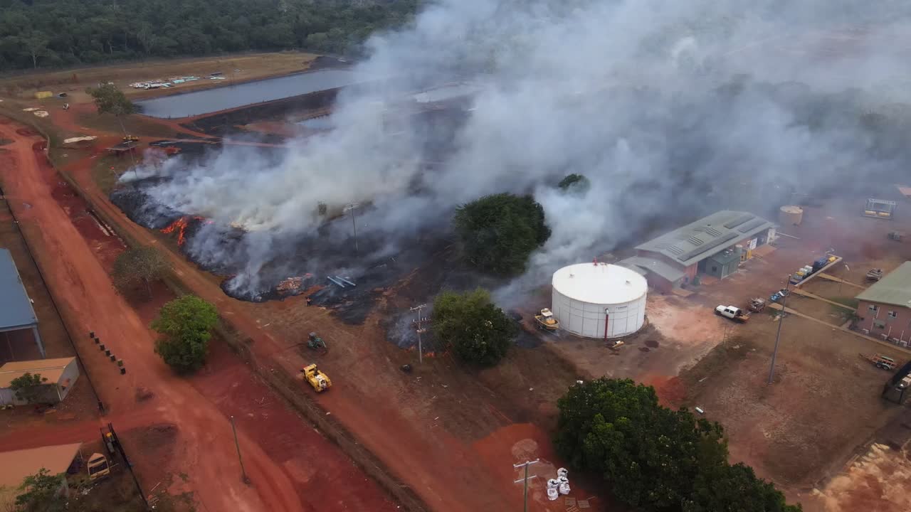 Aerial clip of a wild grass fire and smoke at the edge of a remote community in Cape York, Australia. Clip 1