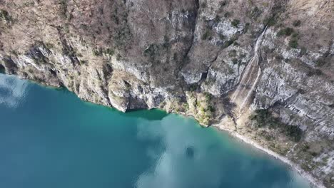 A-mesmerizing-aerial-perspective-captures-the-vibrant-hues-of-Walensee's-waters-and-shoreline-in-Quinten,-Schweiz