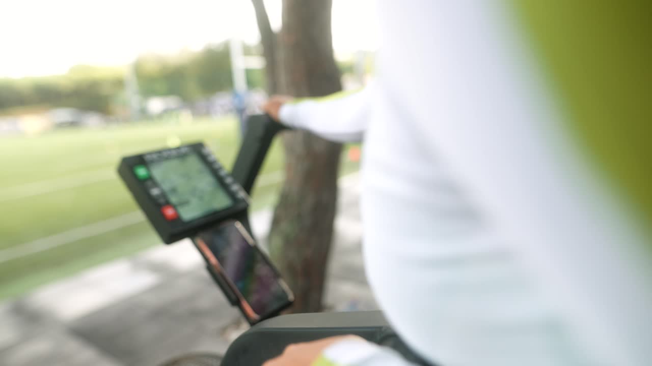 Donna che si allena su una cyclette ad aria in una palestra all'aperto