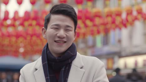 portrait of smiling young asian man in chinatown london uk 1