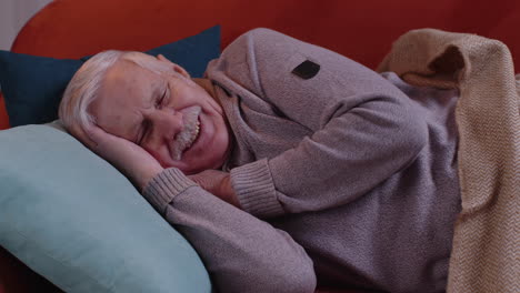 Elderly-smiling-man-grandfather-sleeping-quietly-lying-on-bed-at-home,-healthy-good-peacefully-sleep