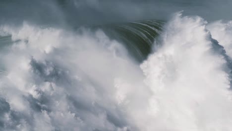 slow motion of two big waves in nazaré, portugal getting together