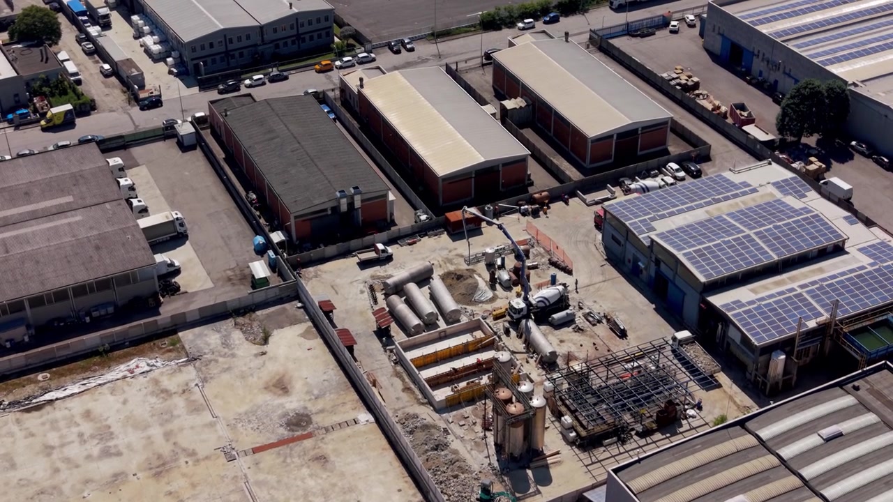 Veduta aerea con drone di un impianto chimico in costruzione in una zona industriale di Milano, Italia. Grandi strutture, gru e infrastrutture mostrano un attivo sviluppo dell'industria pesante.