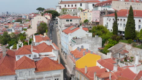 Cámara-De-Drones-Voladores-Sobre-Una-Calle-Estrecha-Que-Conduce-Cuesta-Arriba-Al-Gran-Edificio-Sacro,-La-Iglesia-De-Gracia-Y-El-Convento-De-Nuestro-Complejo-Madre-De-Gracia.-Lisboa,-Capital-De-Portugal.