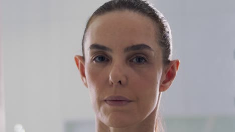 Middle-aged-brunette-woman-with-make-up-on-looking-into-camera-indoors