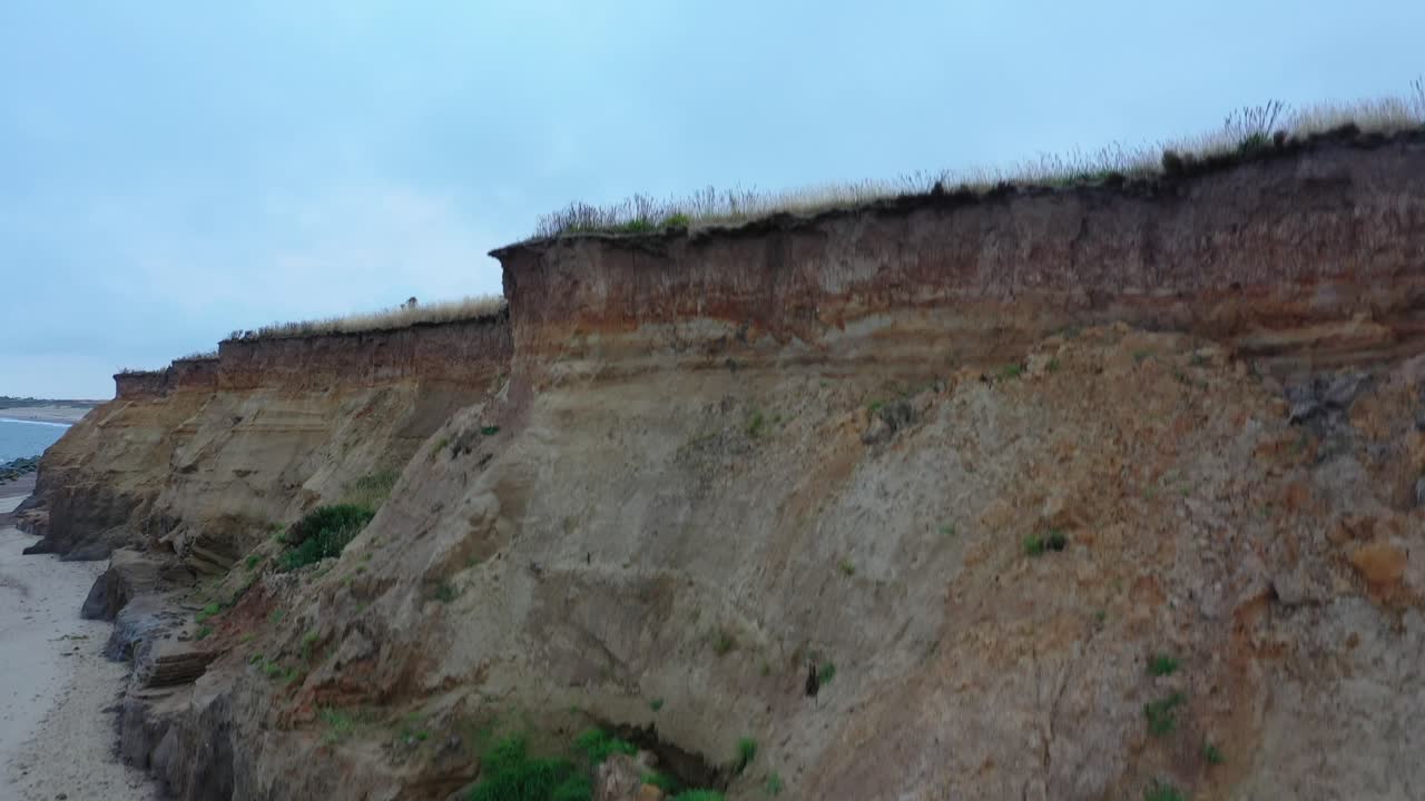 imágenes aéreas en aumento desde la playa hasta los acantilados que revelan el faro de happisburgh al amanecer