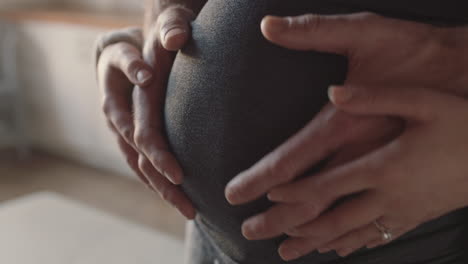 close up hands on pregnant belly proud couple embracing parentood husband gently holding wife enjoying security excited for motherhood