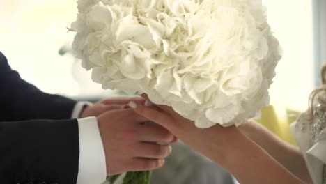 groom gives the bride a wedding bouquet close-up