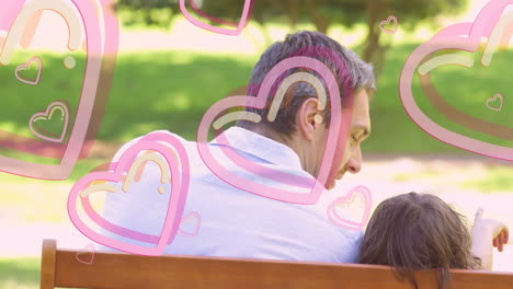 surrounded by animated pink hearts, man sitting on bench with child