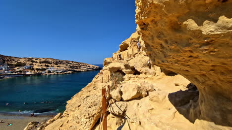 hikers on limestone caves on the beach of matala, crete, greece. dolly shot