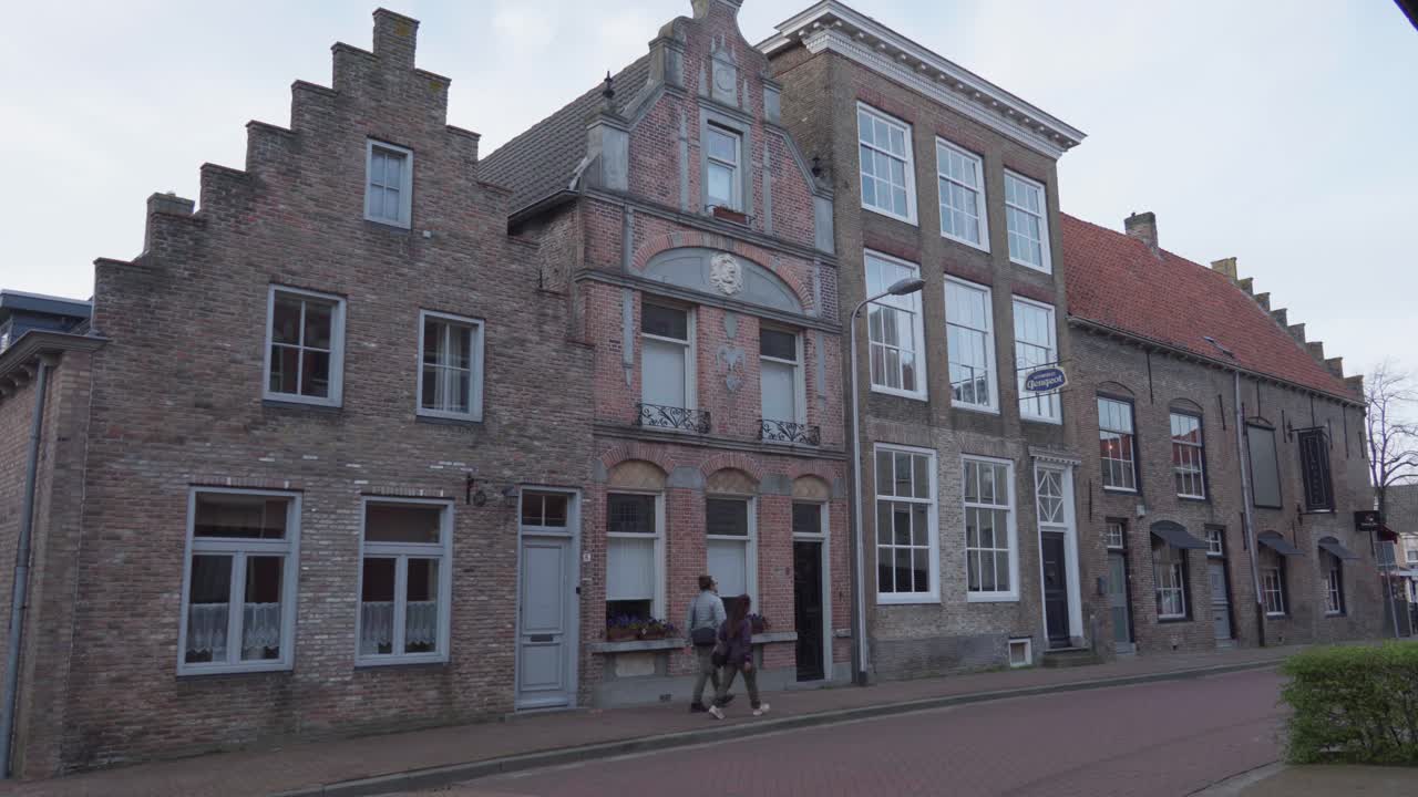 Visitors sightseeing, traditional Dutch buildings, small town location