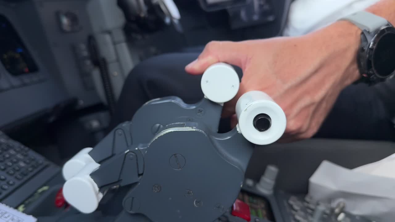 Close-up view of the left hand of a caucasian pilot starting up the right engine of a jet activating the thrust lever