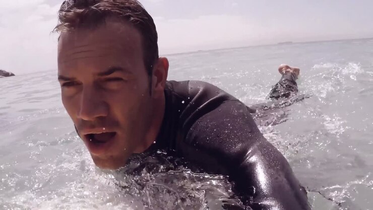 Handsome man surfing in the sea