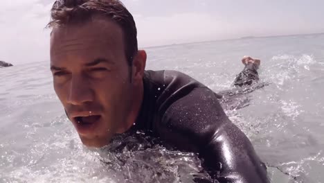 hombre guapo surfeando en el mar