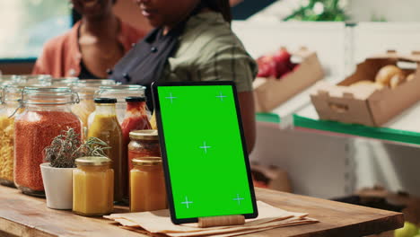 tableta con pantalla verde en el mostrador del mercado de agricultores