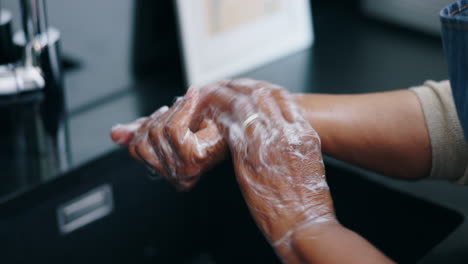 water, soap and person washing hands in bathroom