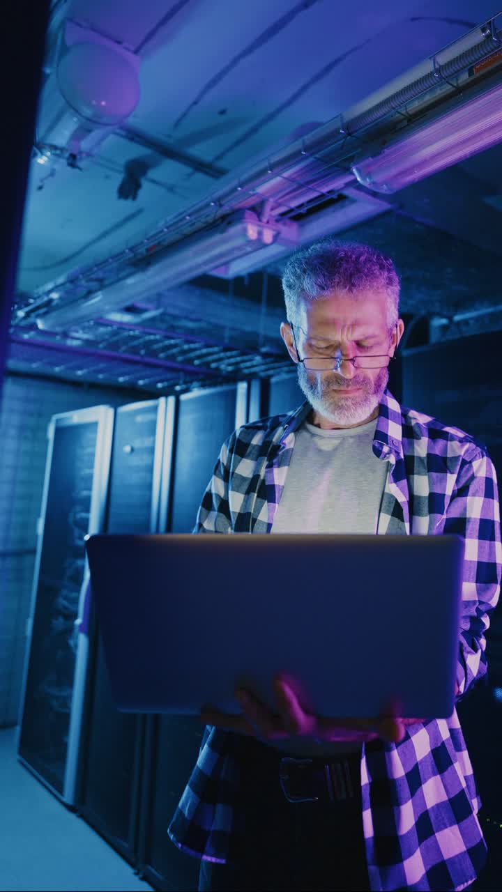 Technician working in a server room at night