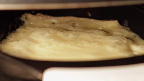 extreme close-up of raclette slice cheese melting and bubbling