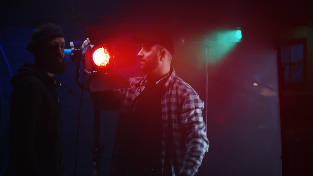 equipo de filmación instalando luces en un set de filmación