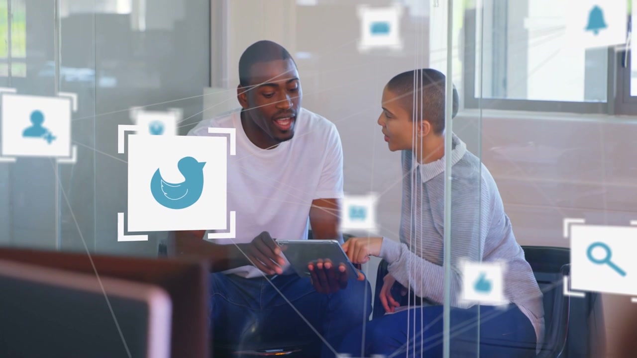 Team pointing and tapping tablet in glass pod causing floating social icons showing business tools