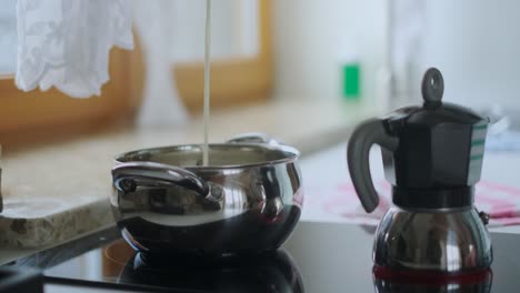 vertiendo leche en una olla