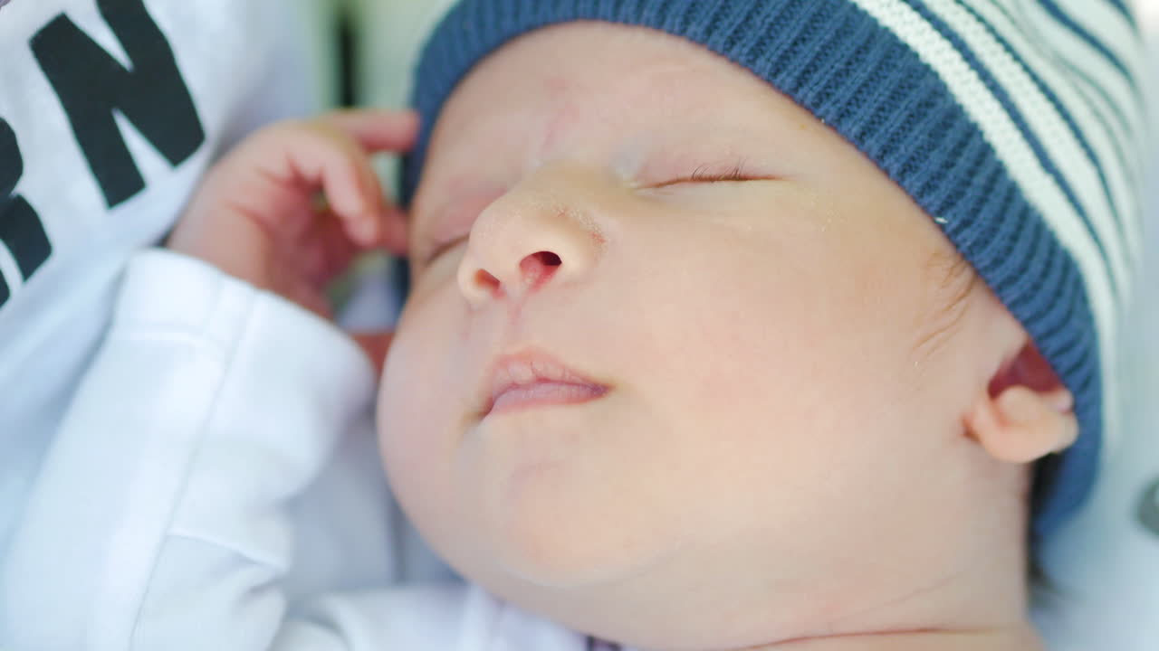 Newborn baby boy smiles while sleeping