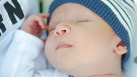 newborn baby boy smiles while sleeping
