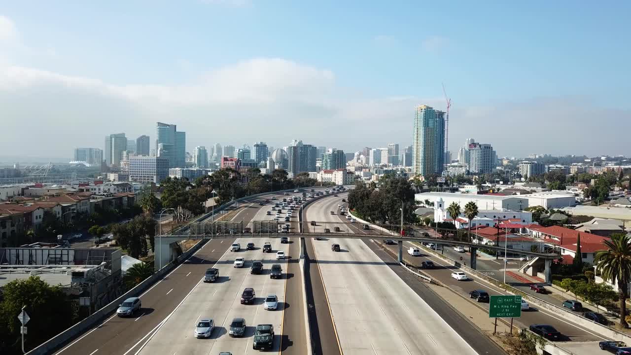 Drone che vola in avanti alle 15:00 verso il centro di San Diego con un soggetto che balla su un ponte e lo skyline sullo sfondo.