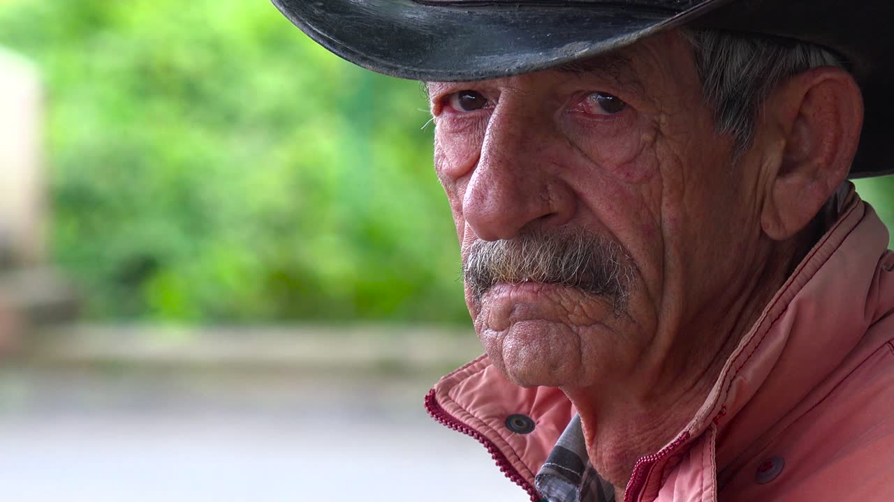 un viejo agricultor de tabaco desgastado en cuba mira la cámara