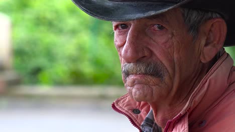 a weathered old tobacco farmer in cuba looks at the camera