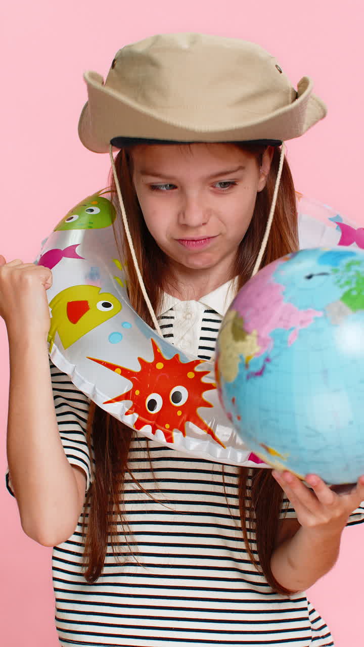 Child girl kid with inflatable ring looking at world map planning holiday trip with excitement