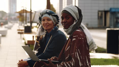 women with laptop posing outdoors