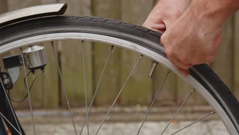 hombre que no utiliza el elevador de neumáticos para quitar el neumático de la bicicleta y falla