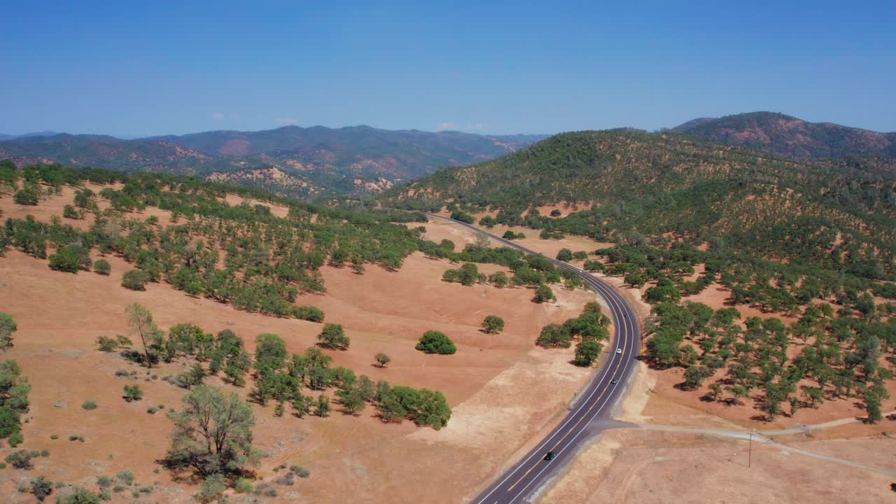 요세미티 국립공원 근처의 경치 좋은 도로를 따라 운전하는 자동차의 공중 드론 샷
