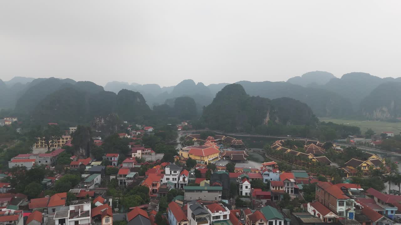 건물, 호수 및 강 근처의 집과 배경의 언덕의 공중 드론