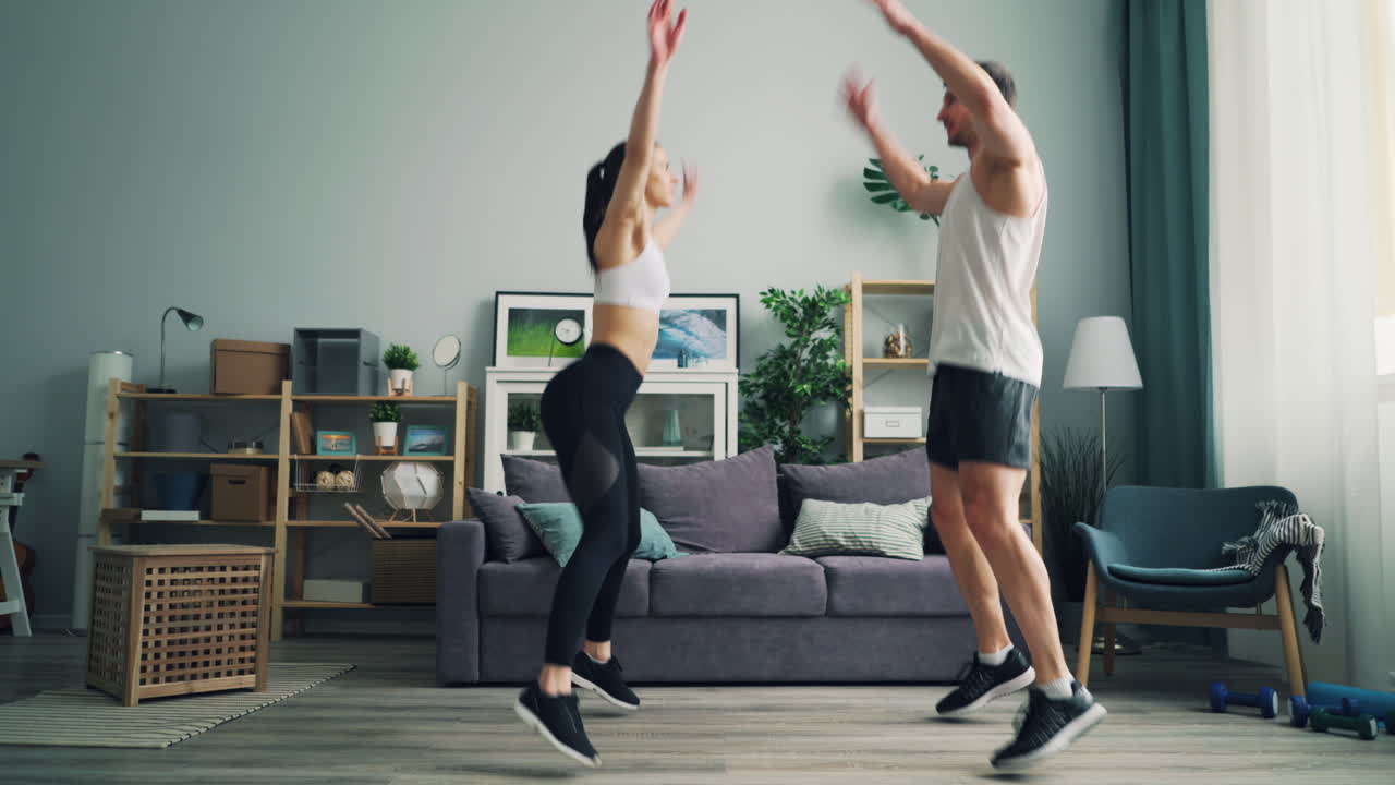 Coppia che fa jumping jacks a casa