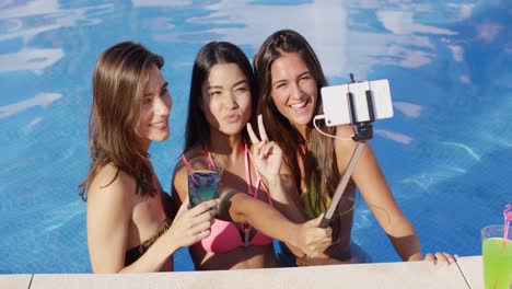 three young women taking a selfie in the pool