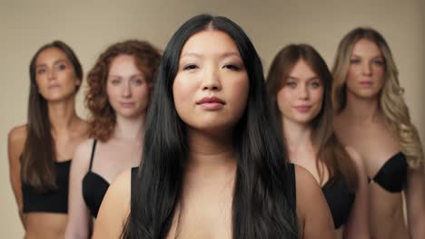 Group-of-confident-women-in-underwear-looking-at-camera-and-standing-in-a-row.