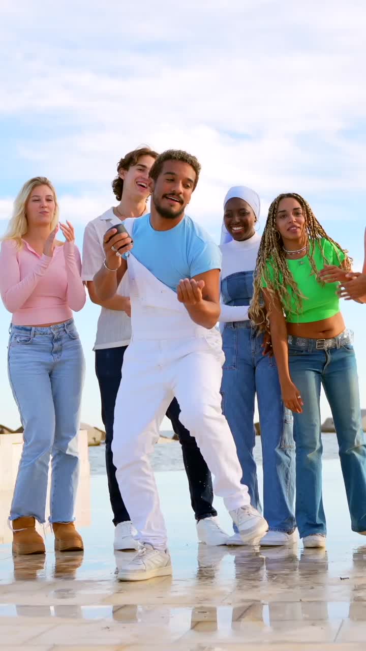 Group of diverse young people dancing and celebrating outdoors