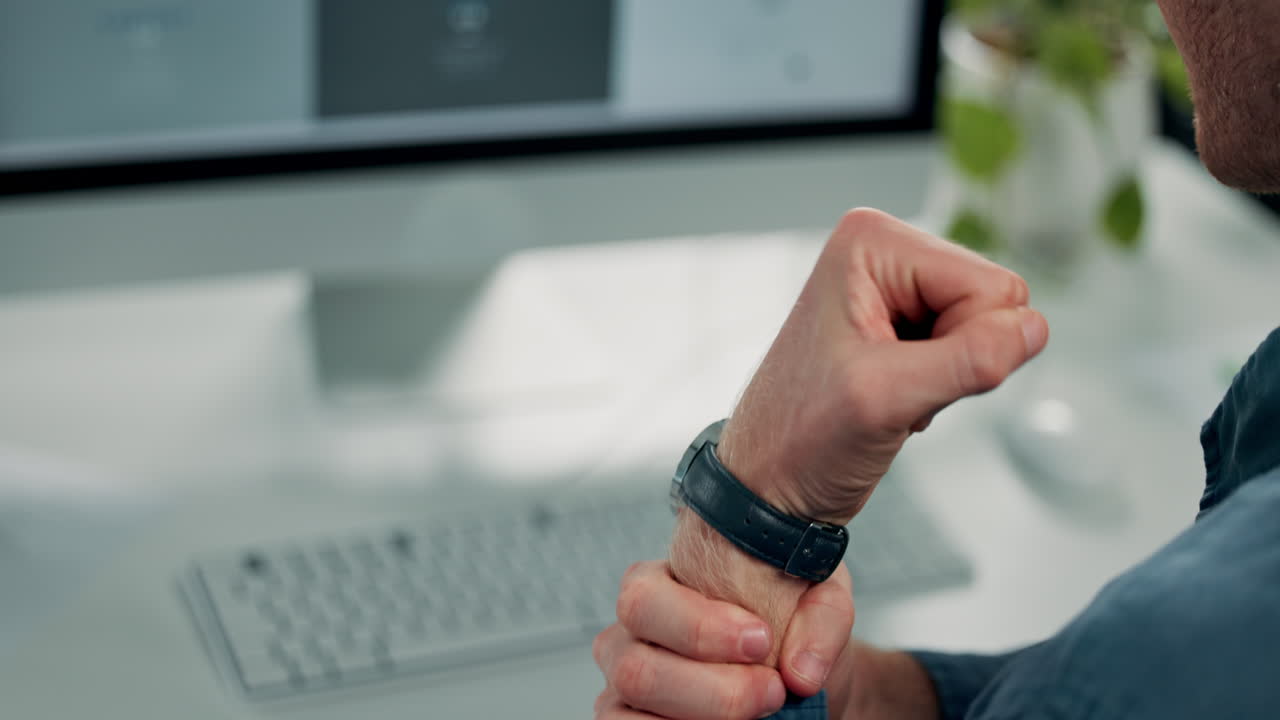 Man experiencing wrist pain while working at computer