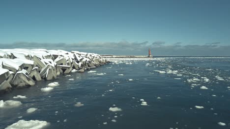 Antenne-über-Schwimmendem-Eisdrift-Neben-Breakwall-In-Omu-Hokkaido-Mit-Rotem-Leuchtturm-Im-Hintergrund