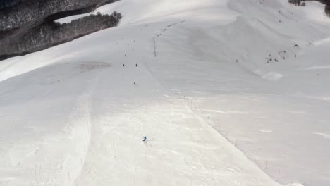 AERIAL---People-skiing-in-mountains-at-Kolasin-ski-resort,-Montenegro,-forward