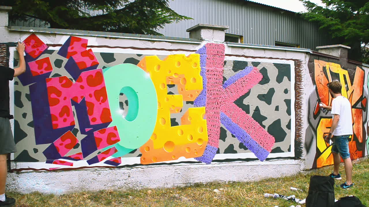 L'artista disegna graffiti su una recinzione. Disegno astratto