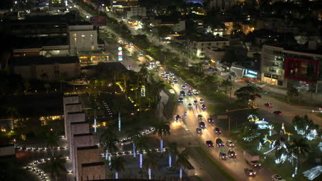 Vista-Aérea-De-Cancun-Mexico-En-La-Noche-Con-Autos-Conduciendo-Por-Av