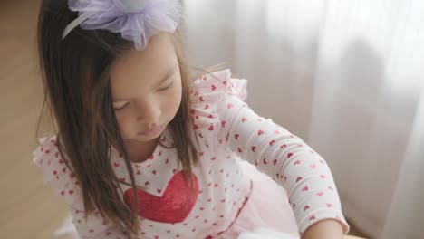 joven sentada en una mesa, dibujando con lápices de colores. ideal para temas de creatividad, desarrollo infantil, aprendizaje y actividades artísticas en un ambiente interior acogedor.
